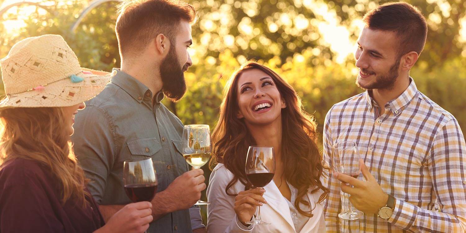 Happy friends having fun drinking wine at winery vineyard - Frie